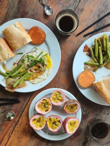 three plates of food on a wooden table at Hoi An Mercy homestay in Hiếu Nhơn