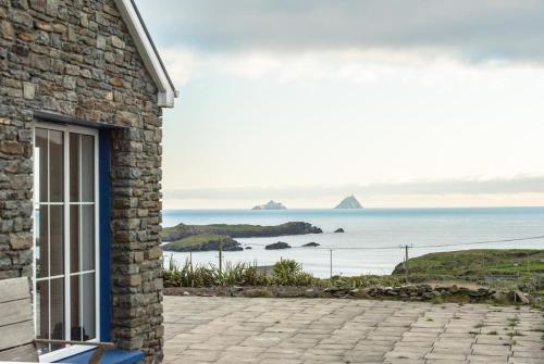 a stone house with a view of the ocean at Ring of Kerry - Einmaliger Blick auf Skelligs in Clynacartan