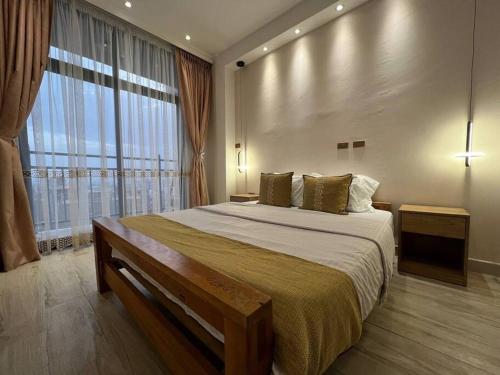 a bedroom with a large bed and a large window at Spacious 2 BR apartment near the airport in Addis Ababa