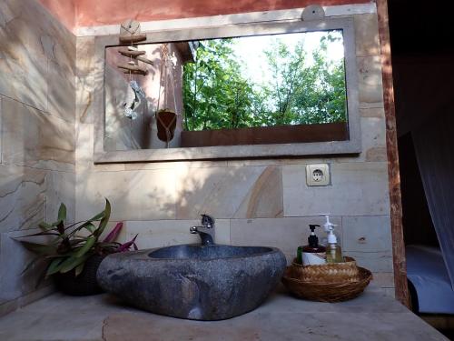 a bathroom with a large stone sink and a mirror at Villa Sea La Vie Private pool in Gili Meno