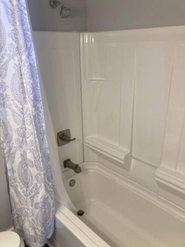 a bathroom with a bath tub with a shower curtain at Farmhouse with game room, fire pit and creek in Johnson City