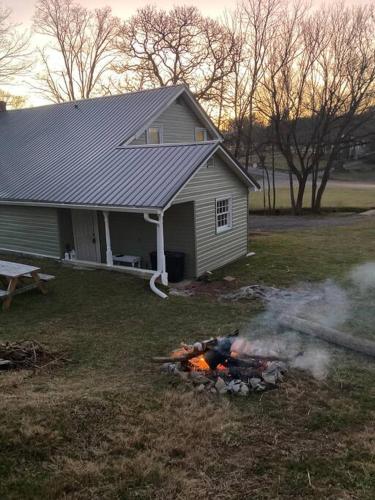 a fire in the yard in front of a house at Farmhouse with game room, fire pit and creek in Johnson City