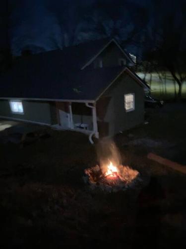 a fire in the yard of a house at night at Farmhouse with game room, fire pit and creek in Johnson City