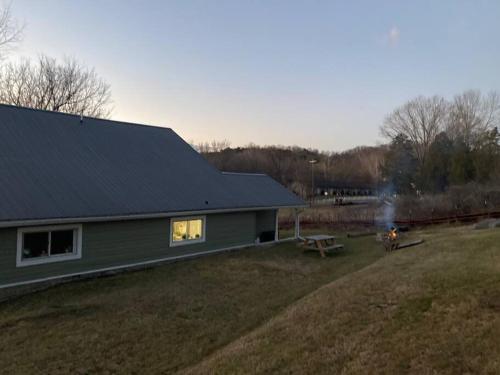 a green house with a picnic table in front of it at Farmhouse with game room, fire pit and creek in Johnson City