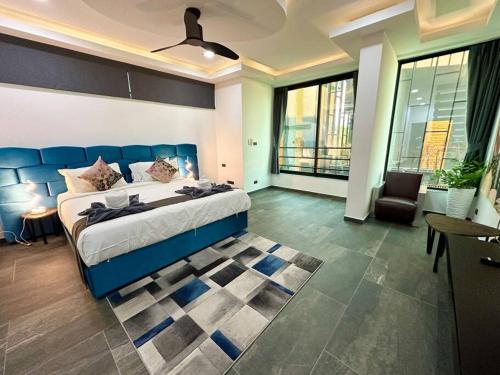 ジョムティエンビーチにあるHuge Luxury, 3 Bedroom, private pool villa near to the beach - Jomtien - LV99のベッドルーム(大型ブルーベッド1台付)、リビングルームが備わります。