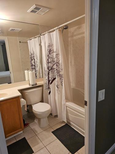 a bathroom with a toilet and a shower curtain at Private Ensuite Room in Luxury Condo in Toronto