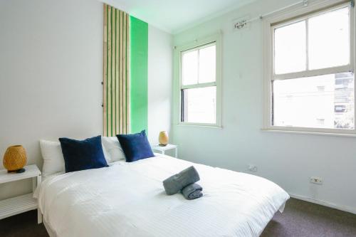 a bedroom with a large white bed with blue pillows at Superb 2 Bedroom House Darlinghurst 2 E-Bikes Included in Sydney