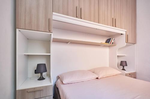 - une chambre avec un lit et des armoires blanches dans l'établissement appartamento a due passi dal mare, à Bellaria-Igea Marina