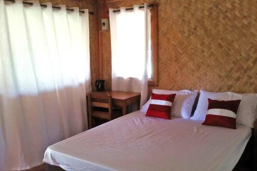 a bedroom with a white bed and a window at Sweet native Guesthouse in Paradise Garden in Puerto Princesa City