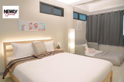 Un dormitorio blanco con dos camas y una ventana. en BnB98 Silom Hotel, en Bangkok