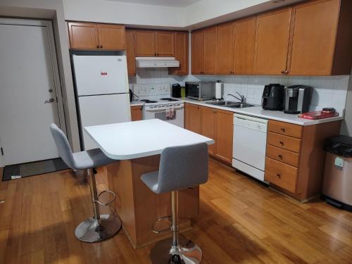 kuchnia z drewnianymi szafkami i białym blatem w obiekcie Private Ensuite Room in Luxury Condo w mieście Toronto