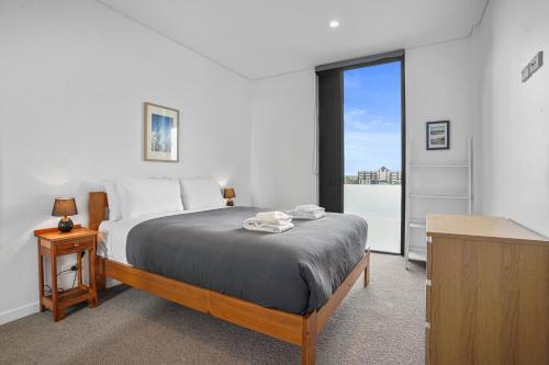 a bedroom with a bed and a large window at Urban Vista - Christchurch Holiday Home in Christchurch