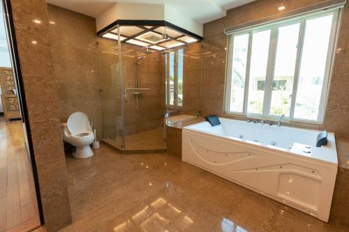 a large bathroom with a tub and a toilet at Andersson Beach House Cebu in Compostela