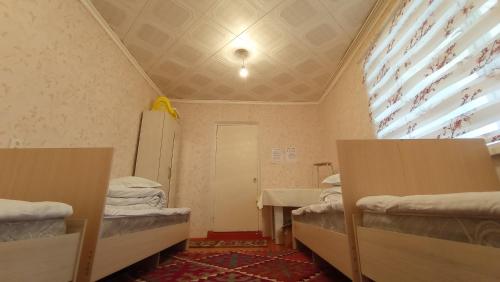 a room with two bunk beds and a window at Happy Hostel in Tamga in Tamga