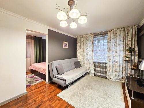 un soggiorno con divano, letto e finestra di Nadezhda Apartments on Nayryzbay batyr 82 a Almaty