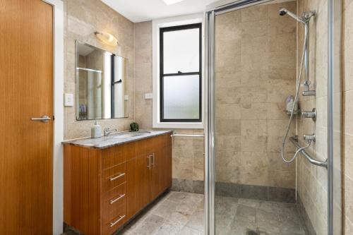 y baño con lavabo y ducha acristalada. en Balmain Retreat - 2BR + Study en Sídney