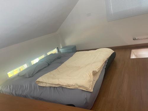 a bed in a small room with a window at Banbangei Riverside Poolvilla in Ban Bang Rathuk