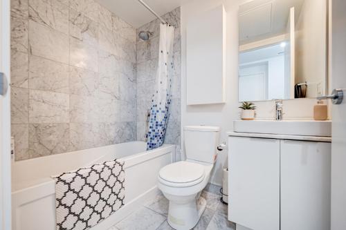 a white bathroom with a toilet and a sink at Downtown Toronto APT in Toronto
