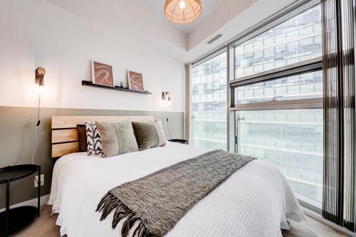 een slaapkamer met een bed en een groot raam bij Downtown Toronto APT in Toronto