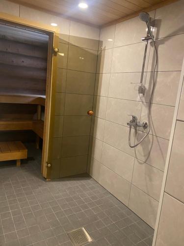 een badkamer met een douche en een glazen deur bij Soosaare Holiday House in Nasva