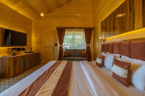 a bedroom with a large bed and a television at La Cabana Beach & Spa, By Ashvem Beach in Mandrem