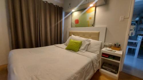 - une chambre avec un lit blanc et un oreiller vert dans l'établissement Condo unit 2 Bedroom one oasis fullyfurnished, à Davao