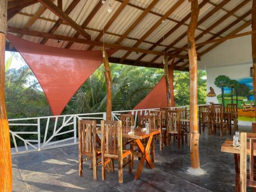a dining room with wooden tables and chairs at Yogi Organic Farm in Komari