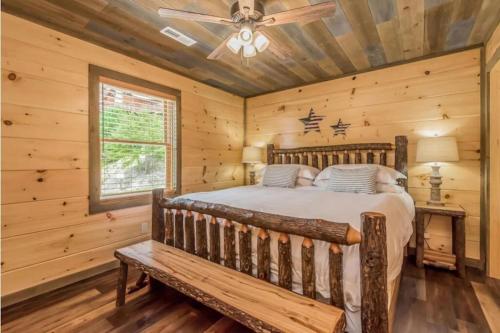 a log cabin bedroom with a bed and a ceiling fan at Freedoms View, Game Room & Amazing Views, FREE tickets each paid day, Hot Tub!!! in Sevierville