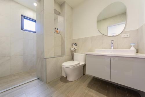 uma casa de banho com um WC, um lavatório e um espelho. em Nan Yi Style em Tainan