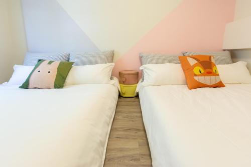 two beds sitting next to each other in a room at Nan Yi Style in Tainan