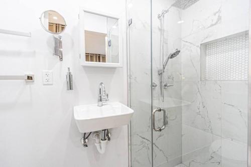 uma casa de banho branca com um lavatório e um chuveiro em Casa Fortim Studio + private + large patio em Miami