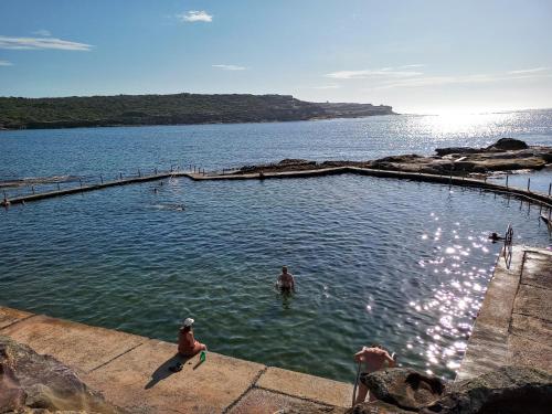 a group of people swimming in a pool in the water at Brand NEW VIP Luxury 5/5 Star Beachside Escape in Sydney