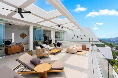 a living room with chairs and tables on a balcony at Golden Lotus Villas in Chaweng