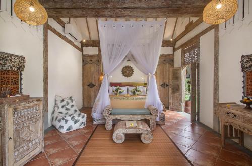 Habitación con hamaca y silla. en Sacred Beji by Pramana Villas en Payangan