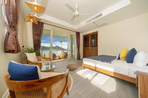 a bedroom with a bed and chairs and a balcony at Stunning 5 bedrooms Villa with Panoramic Sea View in Por Bay