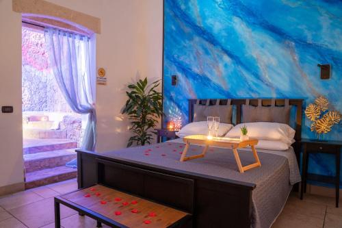 布林迪西的住宿－B&B La Sorgente，一间卧室配有一张带桌子和绘画的床