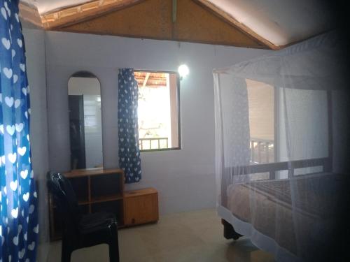 a bedroom with a bed and a mirror and a chair at Agonda Dream View in Agonda