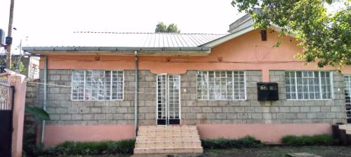 ein Haus mit Fenstern und Treppen davor in der Unterkunft Uthiru Heights in Nairobi