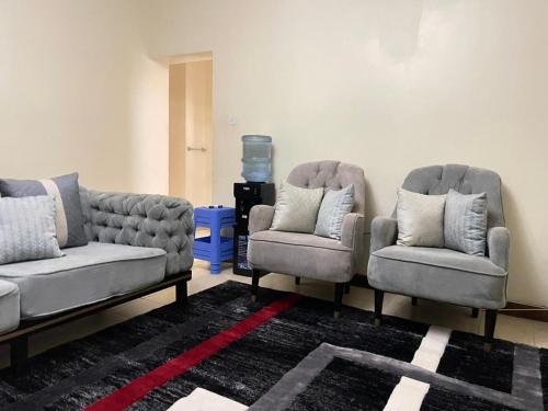 ein Wohnzimmer mit 2 Sofas und 2 Stühlen in der Unterkunft Uthiru Heights in Nairobi