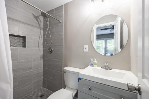 a bathroom with a toilet and a sink and a mirror at Modern Updated Condo Near Downtown in Washington