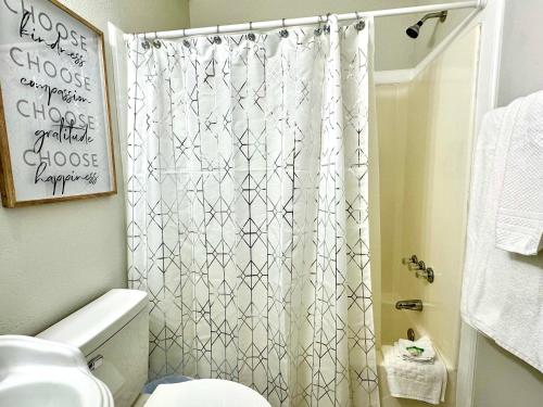 a bathroom with a shower curtain and a toilet at Traveler Stay PLUS in Eagle Pass