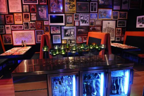 a bar with red chairs and a wall of pictures at Resotel in Villares de la Reina