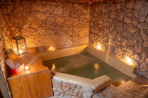 bañera en una habitación de piedra con luces en B&B La Sorgente en Bríndisi