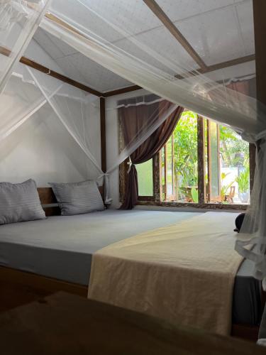 a bedroom with a white bed with a window at Avalon in Weligama