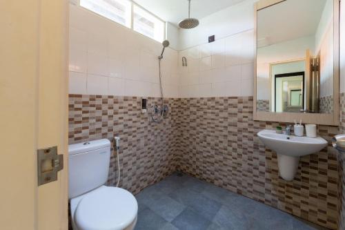 a bathroom with a toilet and a sink at Cove Matahari Senja in Denpasar