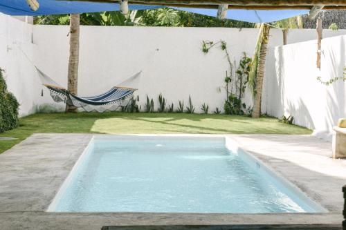 a swimming pool with a hammock in a backyard at Villa Makai 2 Blue in El Paredón Buena Vista
