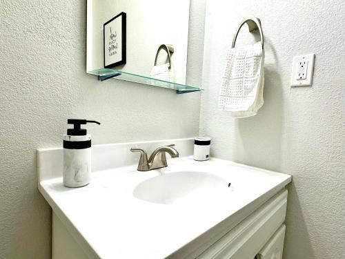 a white bathroom with a sink and a mirror at Traveler Stay PLUS in Eagle Pass