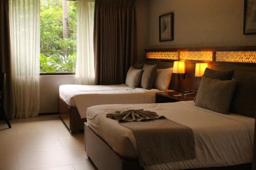 Habitación de hotel con 2 camas y ventana en El Jardin de Zaida Managed by HII en San Juan