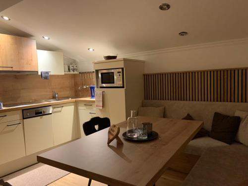 a kitchen with a wooden table and a kitchen with a dining room at Ferienwohnungen Monika Winter in Kleinarl