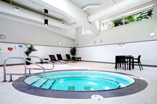 a large pool in a room with a table and chairs at Beautiful Bright Modern Condo with Water view and AC in DT Vancouver 2BR,3BD,2BT sleeps 6 guests Free parking Netflix Included in Vancouver